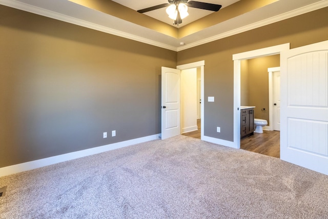 unfurnished bedroom featuring baseboards, crown molding, a tray ceiling, and carpet flooring