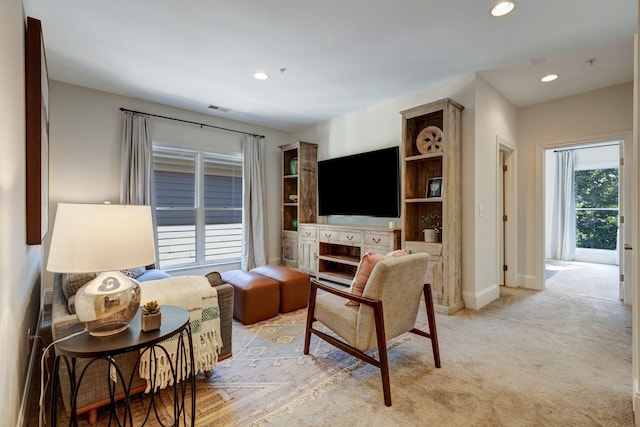 living area featuring baseboards, light colored carpet, and recessed lighting