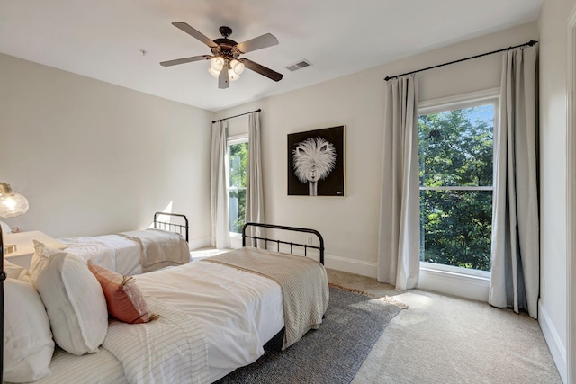 bedroom with carpet floors, baseboards, visible vents, and ceiling fan