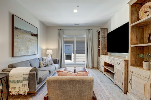 living area with visible vents and light colored carpet