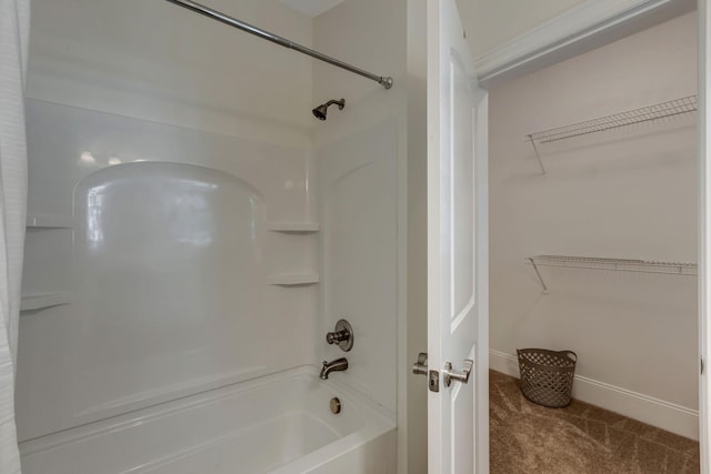 full bathroom with a spacious closet, bathtub / shower combination, and baseboards