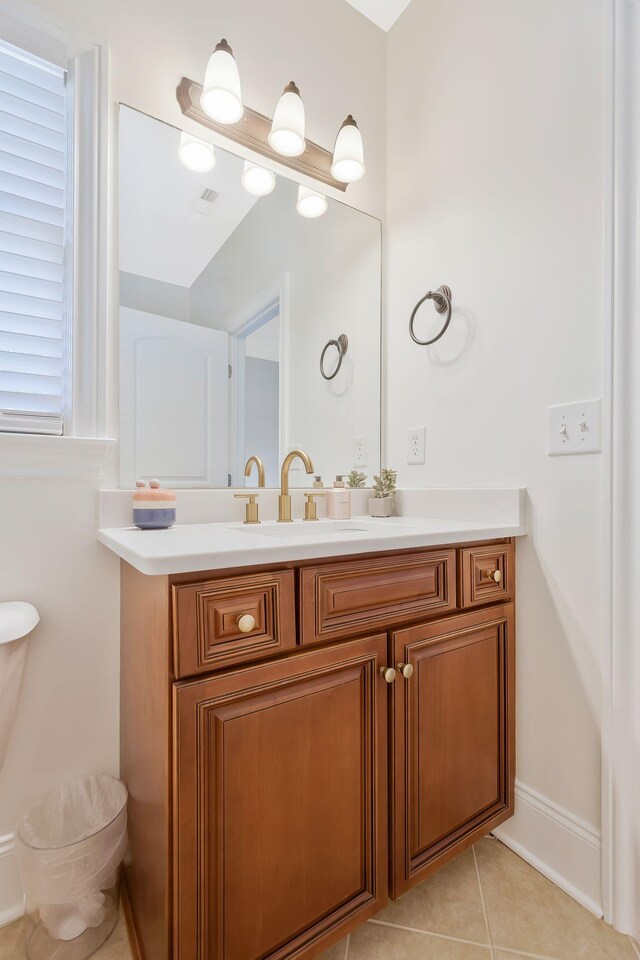 half bathroom featuring toilet, tile patterned flooring, visible vents, and vanity