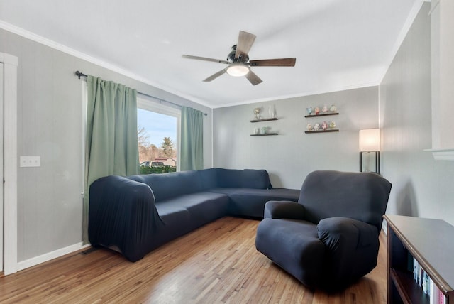 living room with ornamental molding, wood finished floors, a ceiling fan, and baseboards