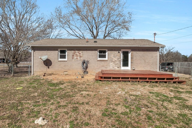 back of property featuring crawl space, brick siding, fence, and a lawn