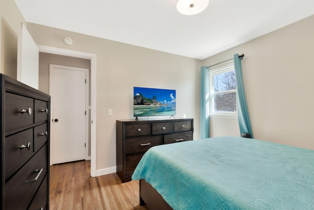 bedroom with light wood-style flooring and baseboards