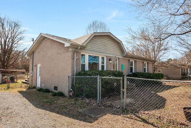 view of front of house with brick siding, crawl space, a fenced front yard, and a gate