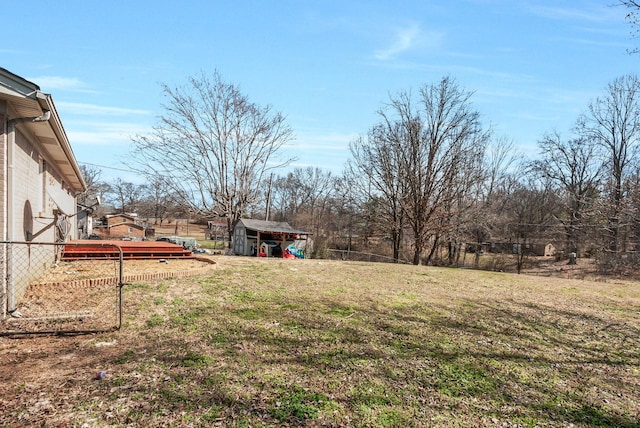 view of yard with a shed, an outdoor structure, and fence