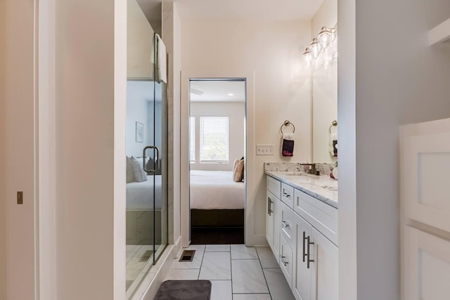 ensuite bathroom with double vanity, visible vents, a stall shower, connected bathroom, and a sink