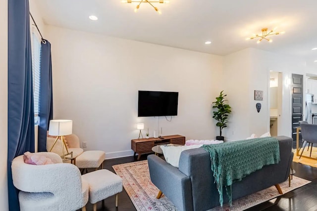 living area with baseboards, an inviting chandelier, wood finished floors, and recessed lighting