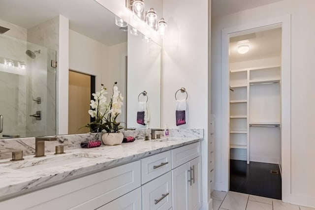 full bath with double vanity, a shower stall, and a sink