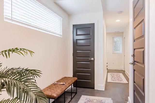 interior space with baseboards, concrete flooring, and recessed lighting