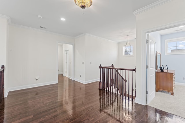 corridor featuring baseboards, visible vents, wood finished floors, crown molding, and an upstairs landing