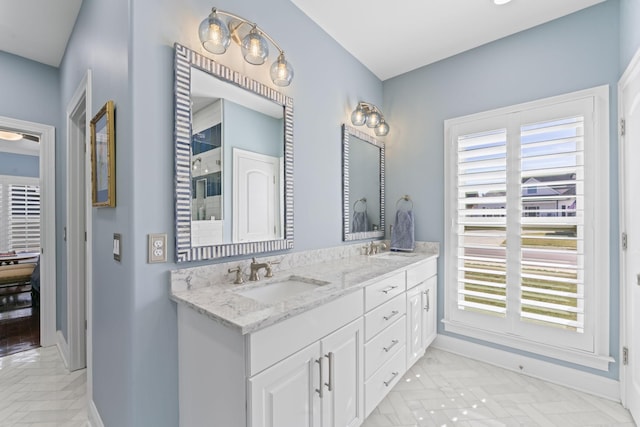 bathroom featuring a sink, baseboards, and double vanity