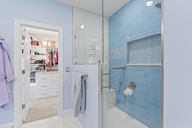 full bathroom featuring an inviting chandelier, a spacious closet, and walk in shower