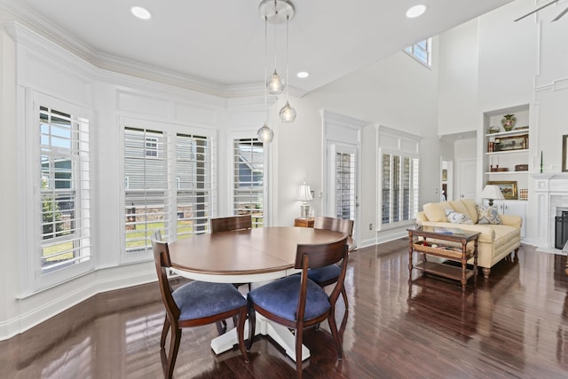 dining area with a fireplace with flush hearth, built in features, dark wood finished floors, and a healthy amount of sunlight