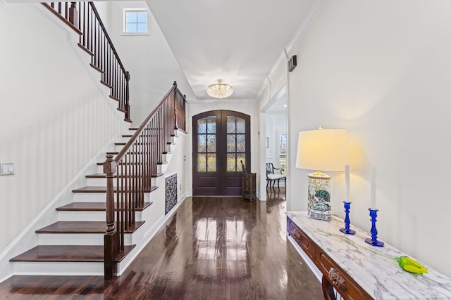 foyer entrance with stairs, french doors, wood finished floors, and crown molding