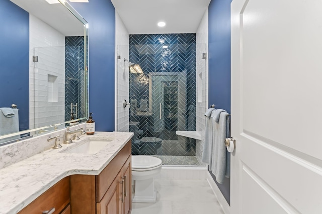 bathroom with a stall shower, vanity, and toilet