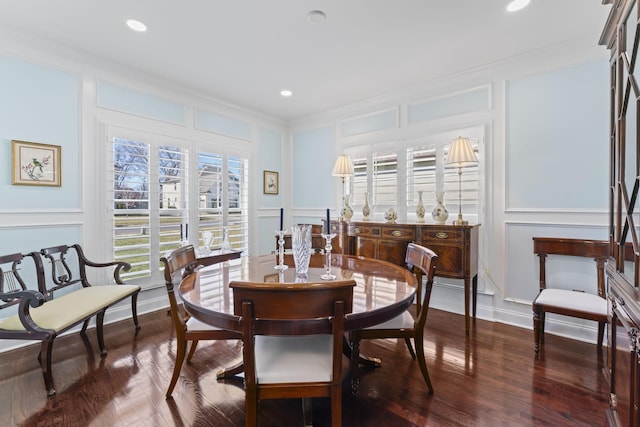 dining room featuring crown molding, wood finished floors, and a decorative wall