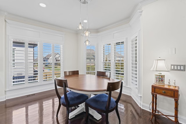 dining room featuring baseboards, visible vents, dark wood-style flooring, and crown molding