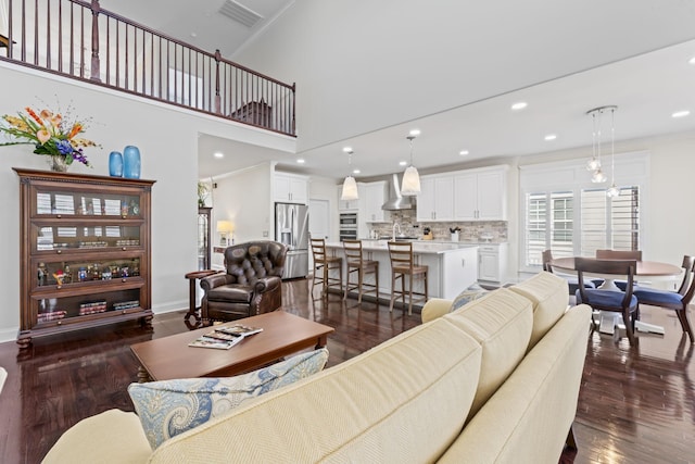 living room with recessed lighting, dark wood-style flooring, crown molding, and baseboards