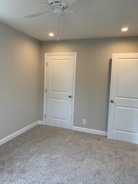 carpeted spare room with recessed lighting, ceiling fan, and baseboards