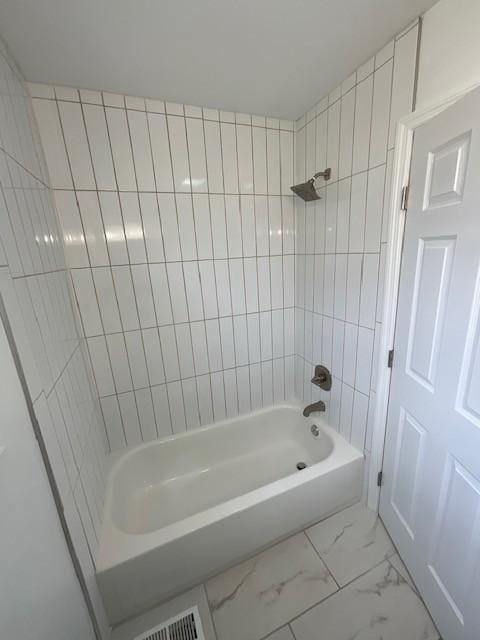 bathroom with marble finish floor, shower / bath combination, and visible vents