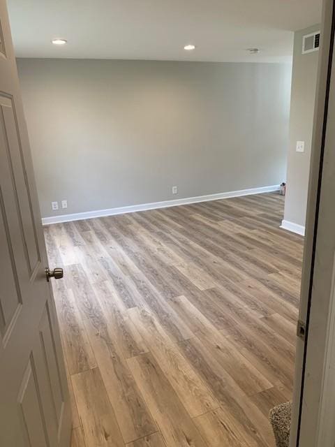 unfurnished room featuring recessed lighting, wood finished floors, visible vents, and baseboards