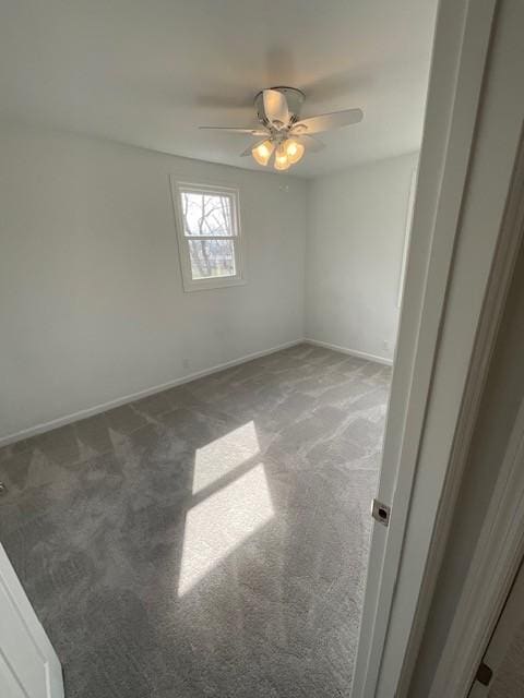 spare room with light carpet, ceiling fan, and baseboards