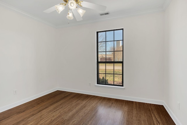 empty room with crown molding, visible vents, dark wood-type flooring, ceiling fan, and baseboards