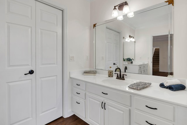 bathroom featuring ornamental molding, a closet, wood finished floors, and vanity