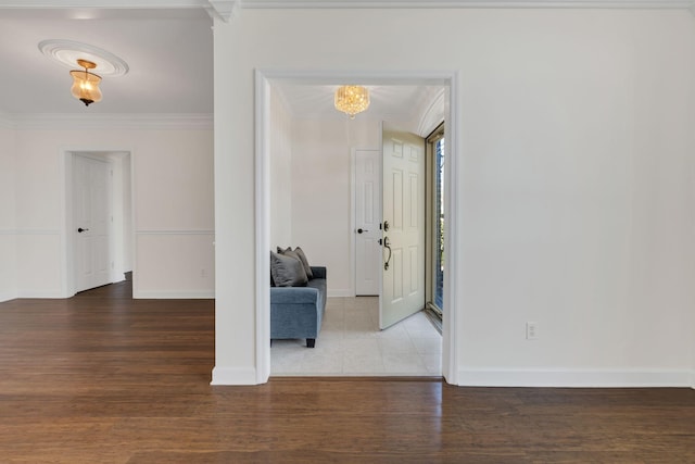 unfurnished room with ornamental molding, baseboards, and wood finished floors