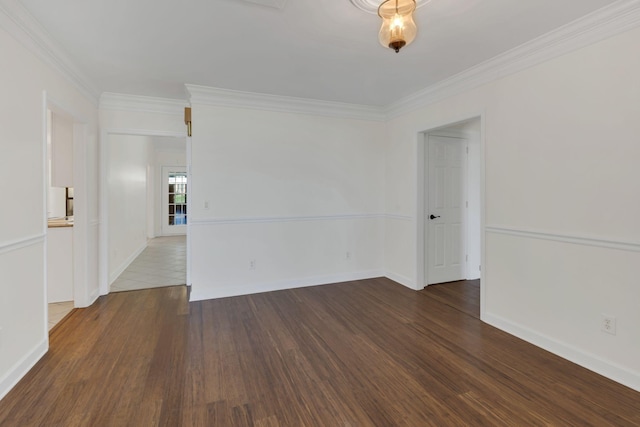 unfurnished room featuring crown molding, baseboards, and wood finished floors