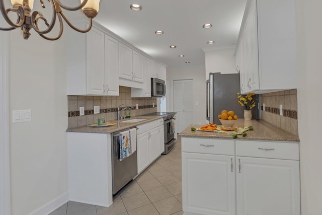 kitchen featuring white cabinets, appliances with stainless steel finishes, crown molding, a sink, and light tile patterned flooring