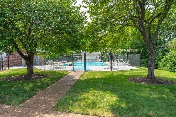 view of home's community with a patio, a lawn, fence, and a pool