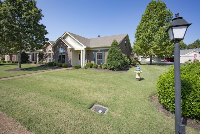 view of front facade with brick siding and a front lawn