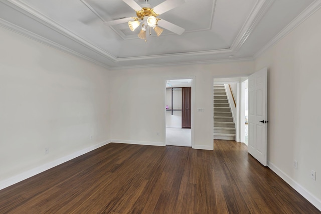 unfurnished room with baseboards, stairway, dark wood-type flooring, a tray ceiling, and crown molding