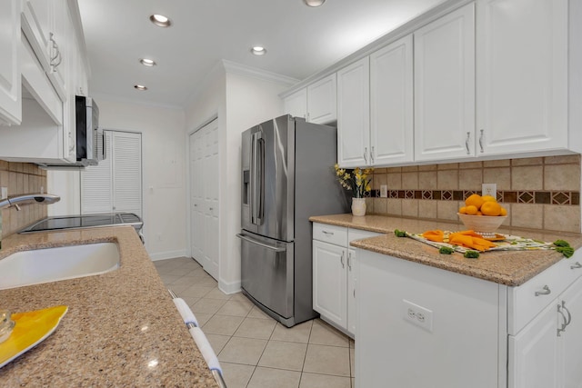 kitchen featuring light tile patterned floors, white cabinets, decorative backsplash, stainless steel appliances, and crown molding