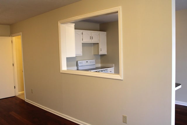 kitchen featuring dark wood-type flooring, white cabinetry, baseboards, and white range with electric cooktop