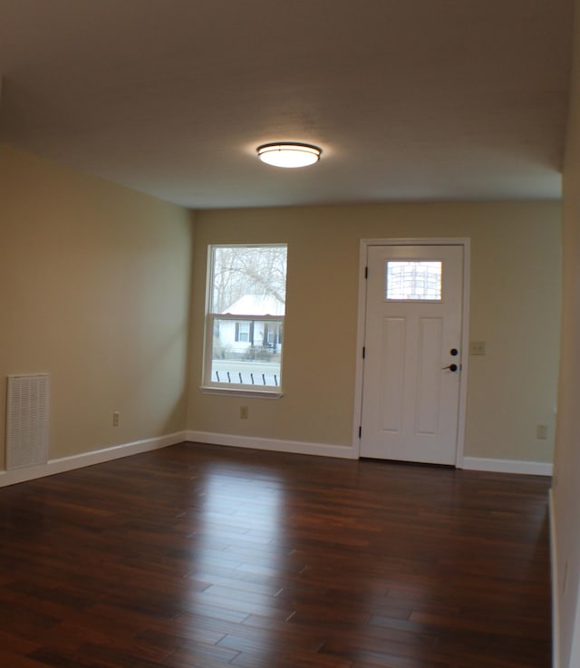 foyer entrance featuring visible vents, dark wood finished floors, and baseboards