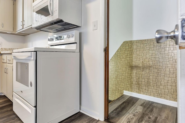 kitchen with light countertops, white appliances, dark wood-type flooring, and baseboards