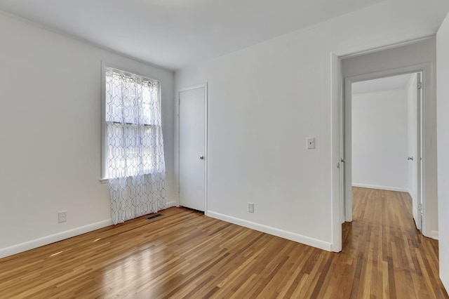 interior space featuring wood finished floors, visible vents, and baseboards