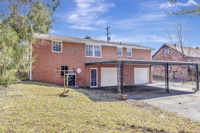 view of front of property with a garage, brick siding, a front yard, and aphalt driveway