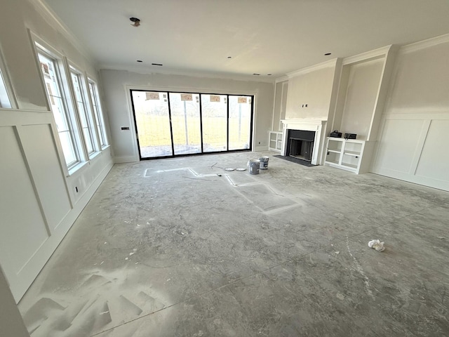 unfurnished living room featuring crown molding, a healthy amount of sunlight, and a decorative wall