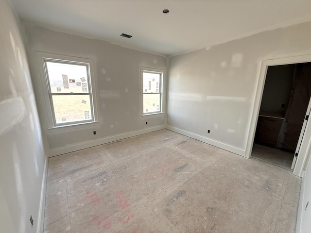 unfurnished bedroom featuring multiple windows, visible vents, and baseboards