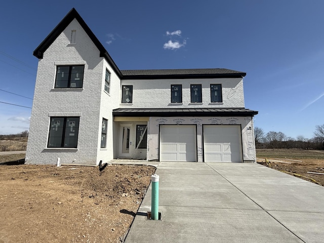 modern inspired farmhouse featuring a garage, concrete driveway, and brick siding