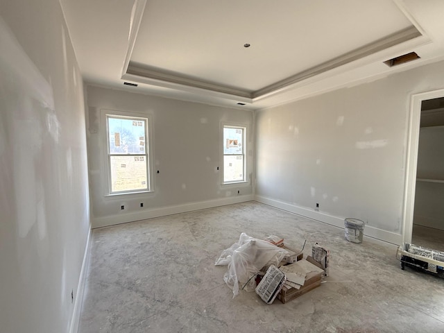 empty room featuring baseboards and a tray ceiling