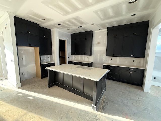 kitchen with light countertops, dark cabinetry, and a center island