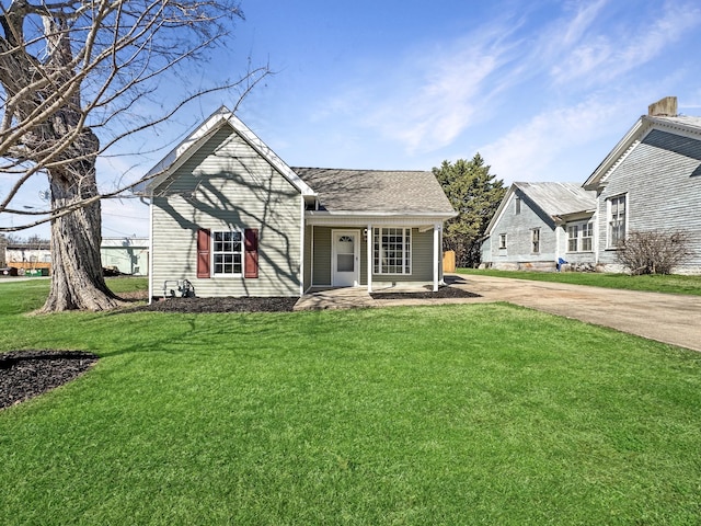 view of front of house featuring covered porch, a shingled roof, and a front yard