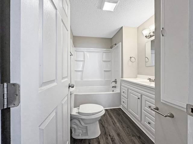 full bathroom with a textured ceiling, toilet, shower / bath combination, wood finished floors, and vanity