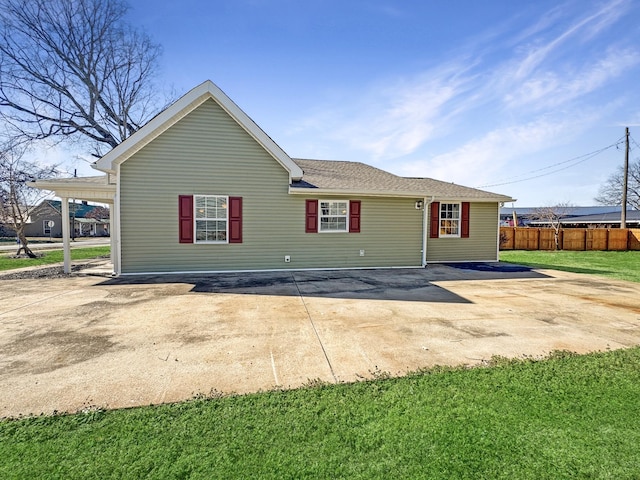 back of property featuring a carport, fence, concrete driveway, and a patio